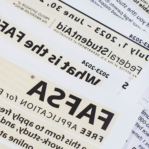 Close-up of printed documents related to the FAFSA (Free Application for Federal Student Aid) for the 2023-2024 academic year. The text highlights key phrases such as 'What is the FAFSA,' 'Federal Student Aid,' and application dates from July 1, 2023, to June 30, 2024.